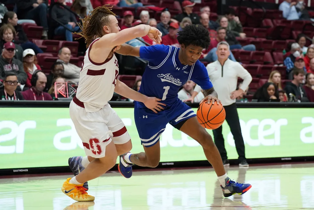 Dec 17, 2025; Stanford, California, USA; Texas-Arlington Mavericks guard Cash Chavis (1) drives on Stanford Cardinal guard Jeremy Dent-Smith (25) in the second half at Maples Pavilion. Mandatory Credit: David Gonzales-Imagn Images
