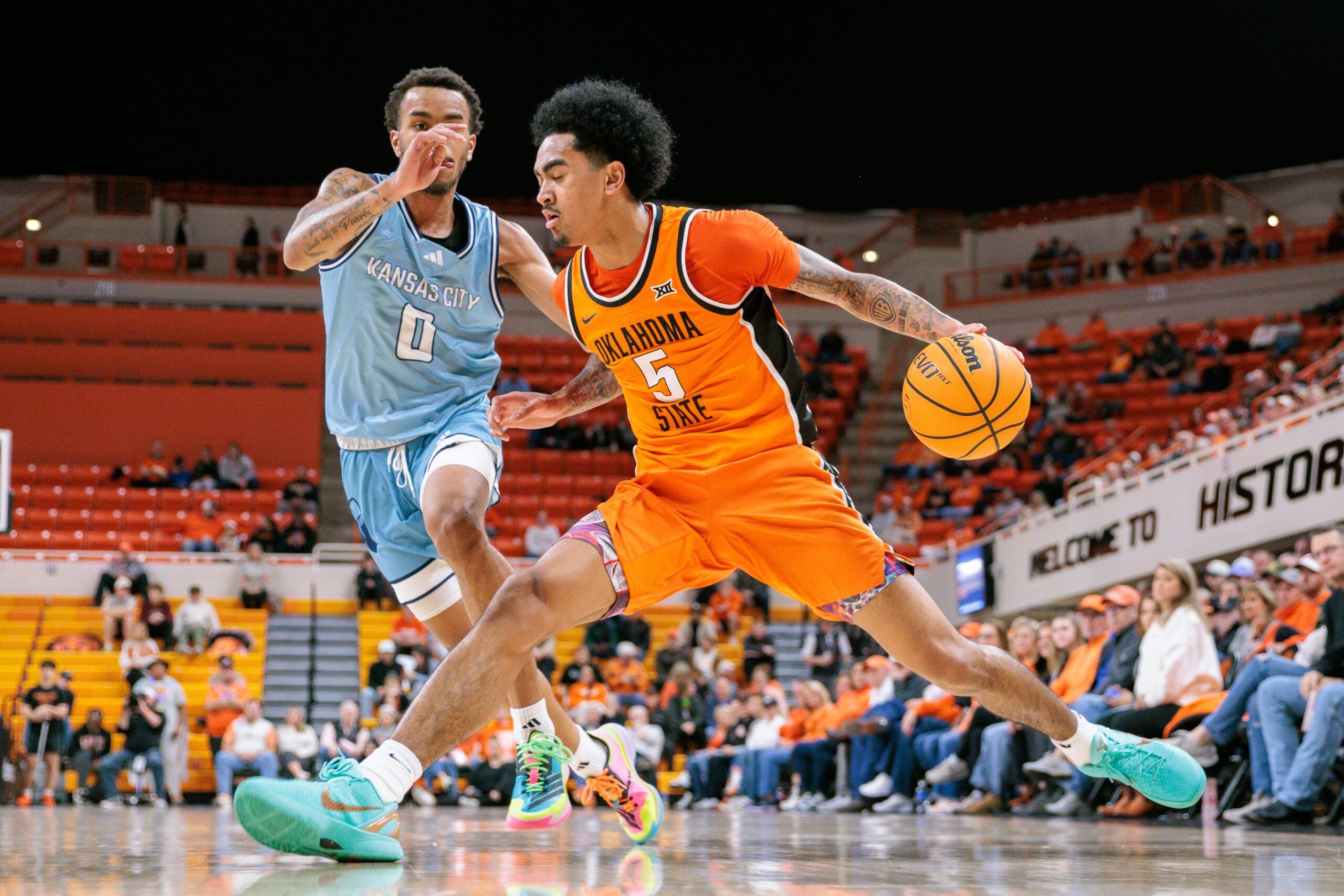 Dec 18, 2025; Stillwater, Oklahoma, USA; Oklahoma State Cowboys guard Vyctorius Miller (5) drives to the basket around Kansas City Roos guard Karmello Branch (0) during the first half at Gallagher-Iba Arena. Mandatory Credit: William Purnell-Imagn Images