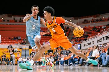 Dec 18, 2025; Stillwater, Oklahoma, USA; Oklahoma State Cowboys guard Vyctorius Miller (5) drives to the basket around Kansas City Roos guard Karmello Branch (0) during the first half at Gallagher-Iba Arena. Mandatory Credit: William Purnell-Imagn Images