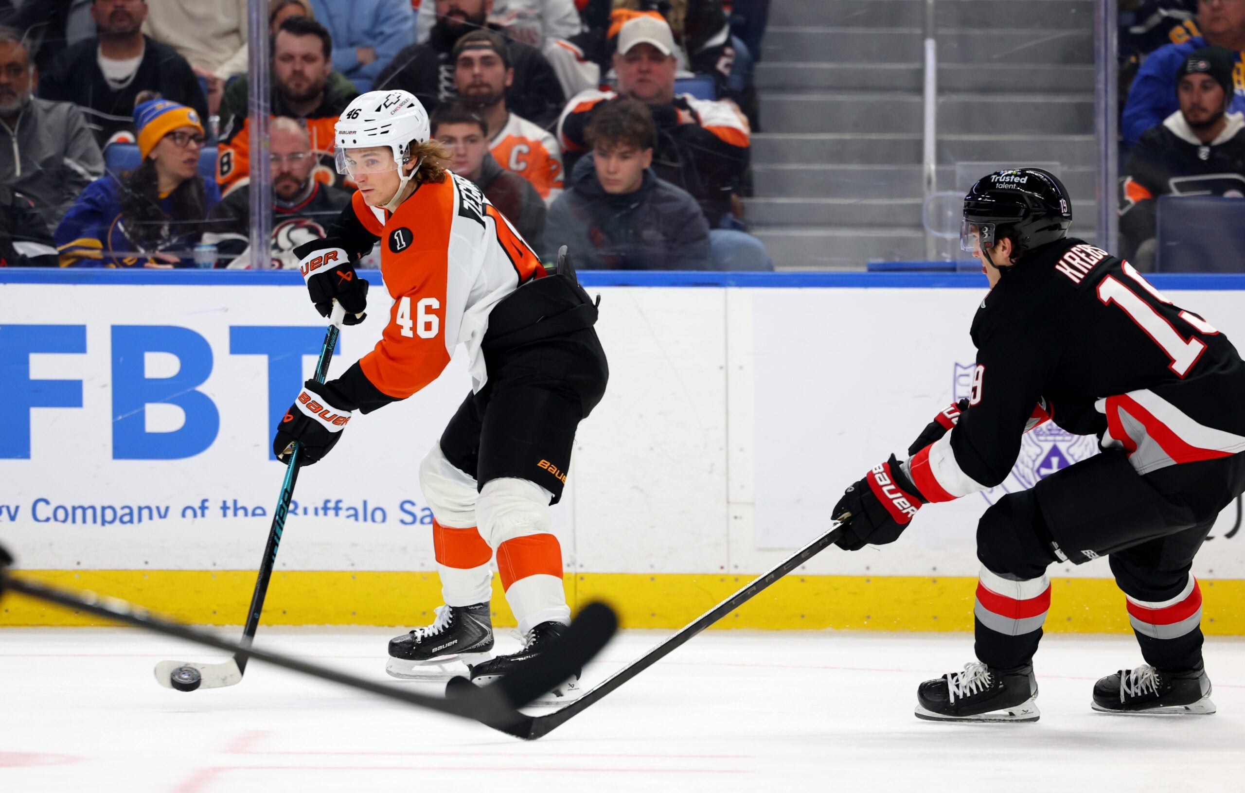 Dec 18, 2025; Buffalo, New York, USA; Philadelphia Flyers center Trevor Zegras (46) makes a pass as Buffalo Sabres center Peyton Krebs (19) tries to block it during the third period at KeyBank Center. Mandatory Credit: Timothy T. Ludwig-Imagn Images