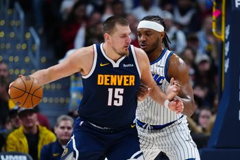 Dec 18, 2025; Denver, Colorado, USA; Orlando Magic center Wendell Carter Jr. (34) defends on Denver Nuggets center Nikola Jokic (15) during the second half at Ball Arena. Mandatory Credit: Ron Chenoy-Imagn Images