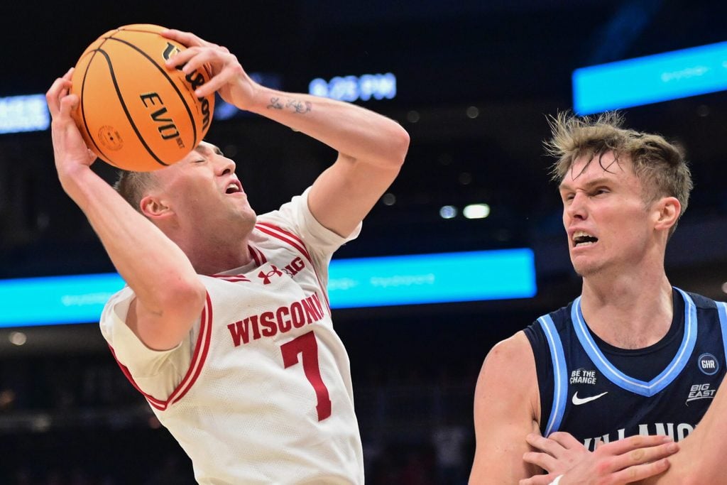 Dec 19, 2025; Milwaukee, Wisconsin, USA; Wisconsin Badgers guard Andrew Rohde (7) grabs a rebound against Villanova Wildcats forward Duke Brennan (24) in the second half at the Fiserv Forum. Mandatory Credit: Benny Sieu-Imagn Images