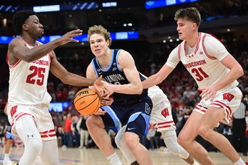 Dec 19, 2025; Milwaukee, Wisconsin, USA; Villanova Wildcats forward Matt Hodge (33) gets pressure from Wisconsin Badgers guard John Blackwell (25) and forward Nolan Winter (31) in the second half at the Fiserv Forum. Mandatory Credit: Benny Sieu-Imagn Images