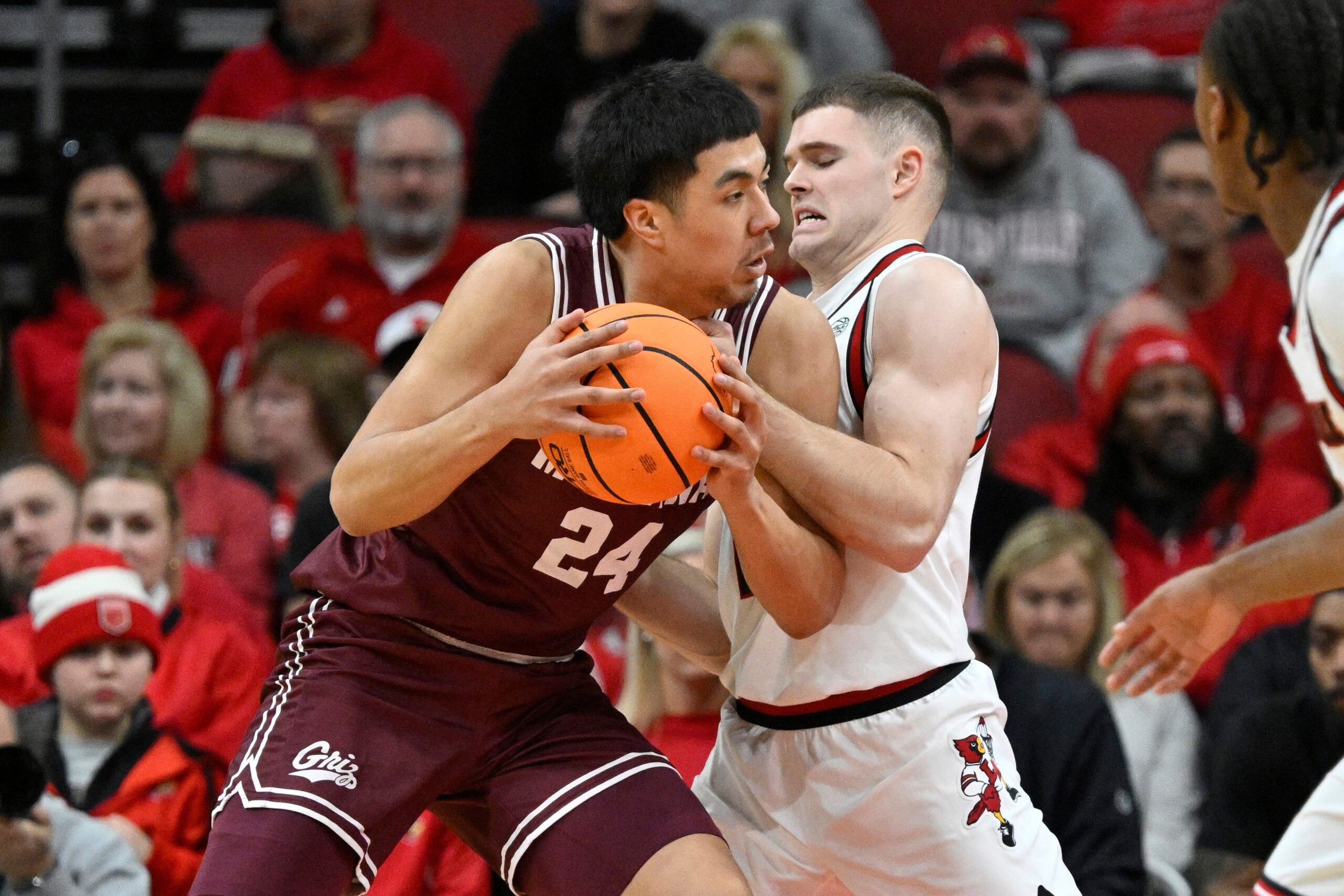 Dec 20, 2025; Louisville, Kentucky, USA;  Montana Grizzlies forward Kenyon Aguino (24) posts up against Louisville Cardinals guard Isaac McKneely (10) during the first half at KFC Yum! Center. Mandatory Credit: Jamie Rhodes-Imagn Images