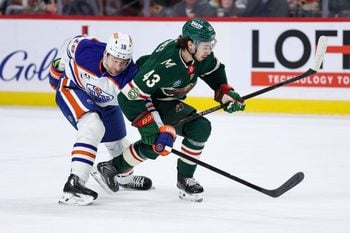Dec 20, 2025; Saint Paul, Minnesota, USA; Minnesota Wild defenseman Quinn Hughes (43) and Edmonton Oilers left wing Zach Hyman (18) compete for the puck during the first period at Grand Casino Arena. Mandatory Credit: Matt Krohn-Imagn Images
