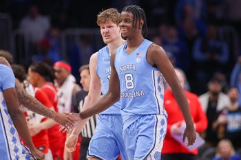 Dec 20, 2025; Atlanta, Georgia, USA; North Carolina Tar Heels forward Caleb Wilson (8) and center Henri Veesaar (13) celebrate during a timeout against the Ohio State Buckeyes in the second half at State Farm Arena. Mandatory Credit: Brett Davis-Imagn Images