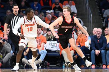 Dec 20, 2025; Syracuse, New York, USA; Northeastern Huskies forward Youri Fritz (7) handles the ball against Syracuse Orange forward Ibrahim Souare (10) in the second half at the JMA Wireless Dome. Mandatory Credit: Mark Konezny-Imagn Images