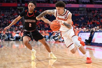Dec 20, 2025; Syracuse, New York, USA; Syracuse Orange guard Nate Kingz (4) drives to the basket against Northeastern Huskies guard Ryan Williams (2) in the second half at the JMA Wireless Dome. Mandatory Credit: Mark Konezny-Imagn Images