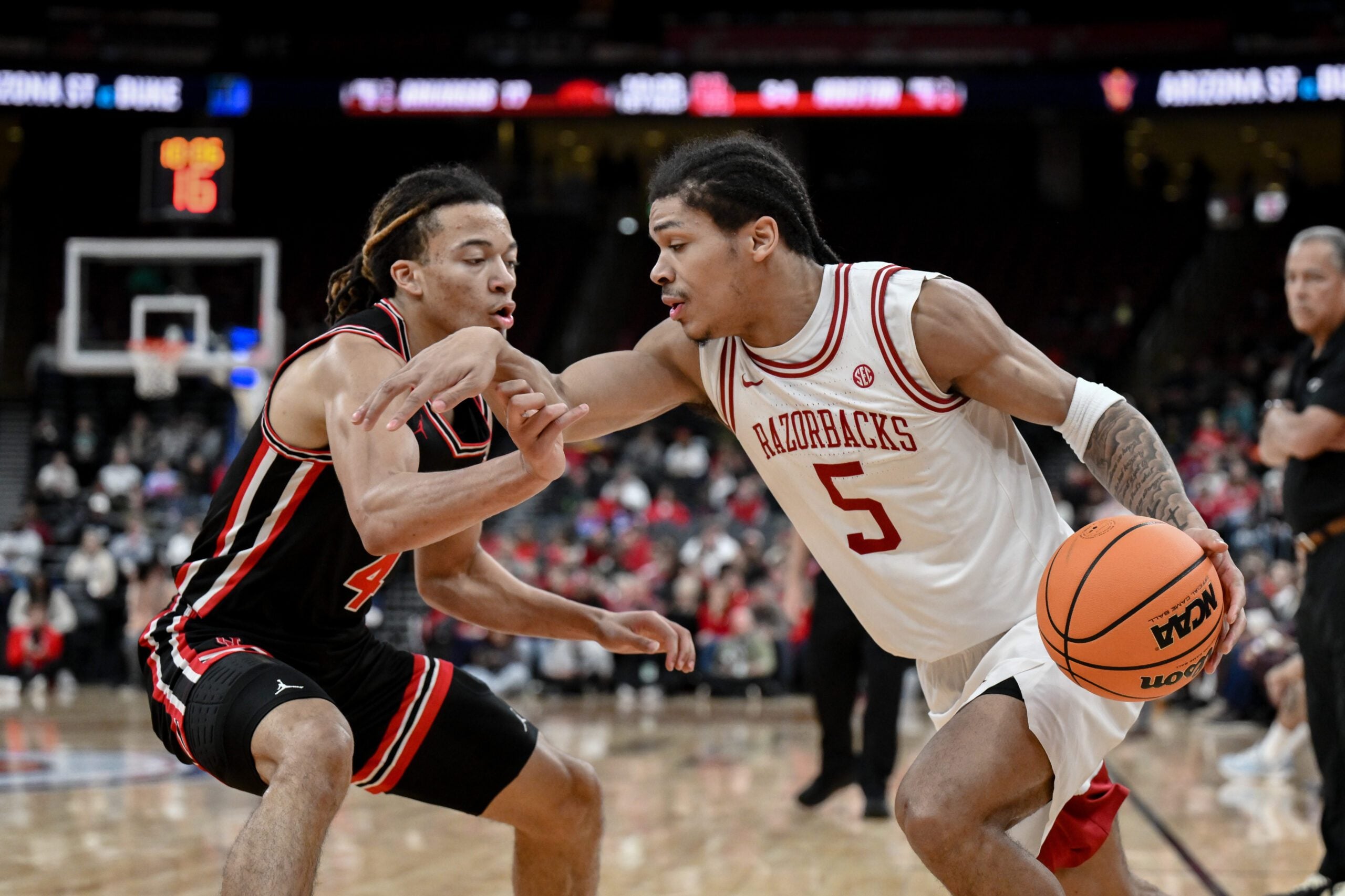 Dec 20, 2025; Newark, New Jersey, USA; Arkansas Razorbacks guard Darius Acuff Jr. (5) tries to drive past Houston Cougars guard Kingston Flemings (4) during the first half at Prudential Center. Mandatory Credit: John Jones-Imagn Images