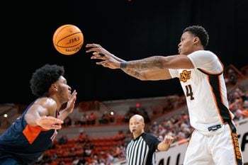 Dec 21, 2025; Stillwater, Oklahoma, USA; Oklahoma State Cowboys guard Christian Coleman (4) passes over Cal State Fullerton Titans guard Christian Williams (7) during the first half at Gallagher-Iba Arena. Mandatory Credit: William Purnell-Imagn Images