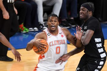Clemson Tigers forward RJ Godfrey (0) drives past Cincinnati Bearcats forward Halvine Dzellat (65) Sunday, Dec. 21, 2025, during the NCAA men’s basketball game at Bon Secours Wellness Arena in Greenville, South Carolina.