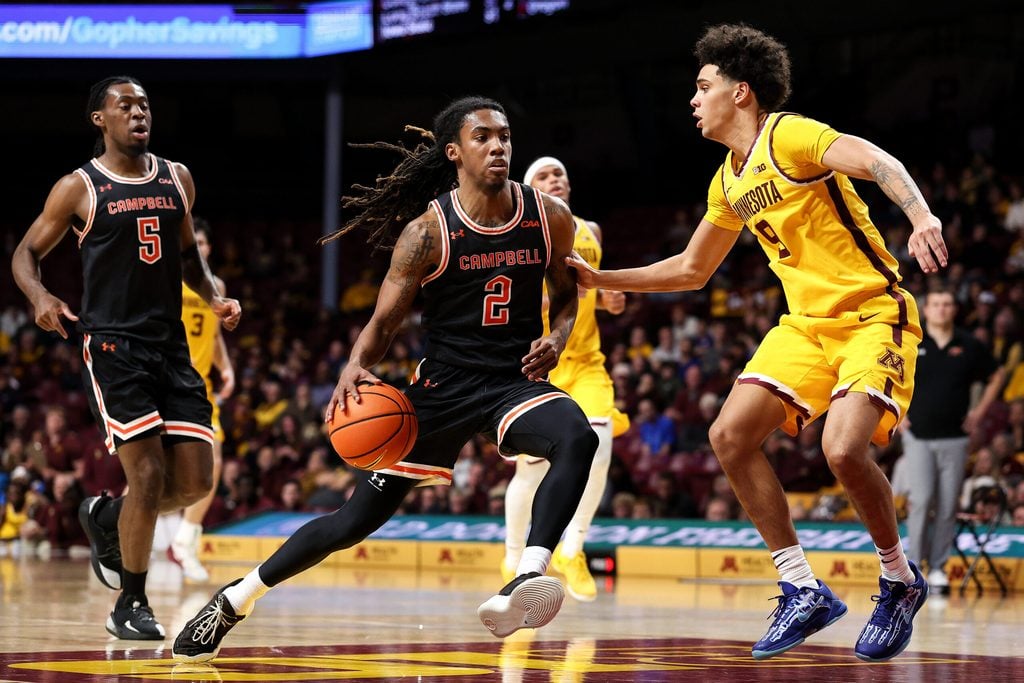 Dec 21, 2025; Minneapolis, Minnesota, USA; Campbell Fighting Camels guard Jeremiah Johnson (2) drives towards the basket as Minnesota Golden Gophers guard Kai Shinholster (9) defends during the second half at Williams Arena. Mandatory Credit: Matt Krohn-Imagn Images