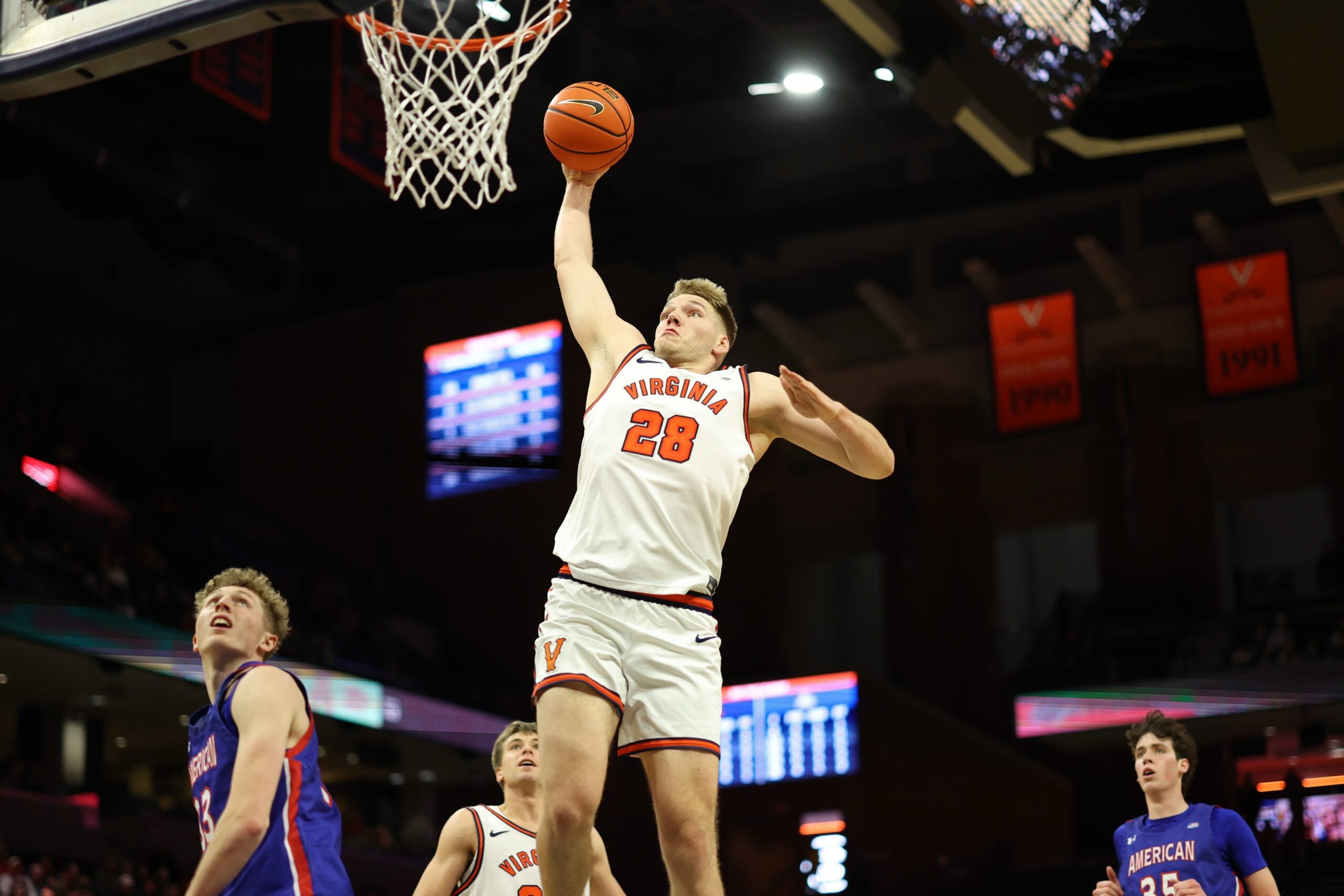 Dec 22, 2025; Charlottesville, Virginia, USA; Virginia Cavaliers forward Thijs de Ridder (28) dunks the ball as American University Eagles forward Matt Mayock (33) and  Eagles forward Chris Eagan (35) look on in the second half at John Paul Jones Arena. Mandatory Credit: Geoff Burke-Imagn Images