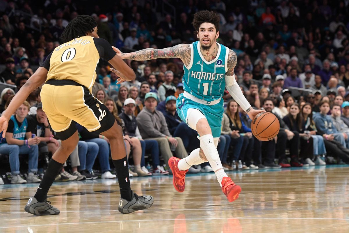 Dec 23, 2025; Charlotte, North Carolina, USA; Charlotte Hornets guard LaMelo Ball (1) drives past Washington Wizards forward Bilal Coulibaly (0) during the second half at the Spectrum Center. Mandatory Credit: Sam Sharpe-Imagn Images