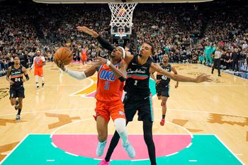 Dec 23, 2025; San Antonio, Texas, USA; Oklahoma City Thunder guard Shai Gilgeous-Alexander (2) drives to the basket past San Antonio Spurs forward Victor Wembanyama (1) during the first half at Frost Bank Center. Mandatory Credit: Scott Wachter-Imagn Images