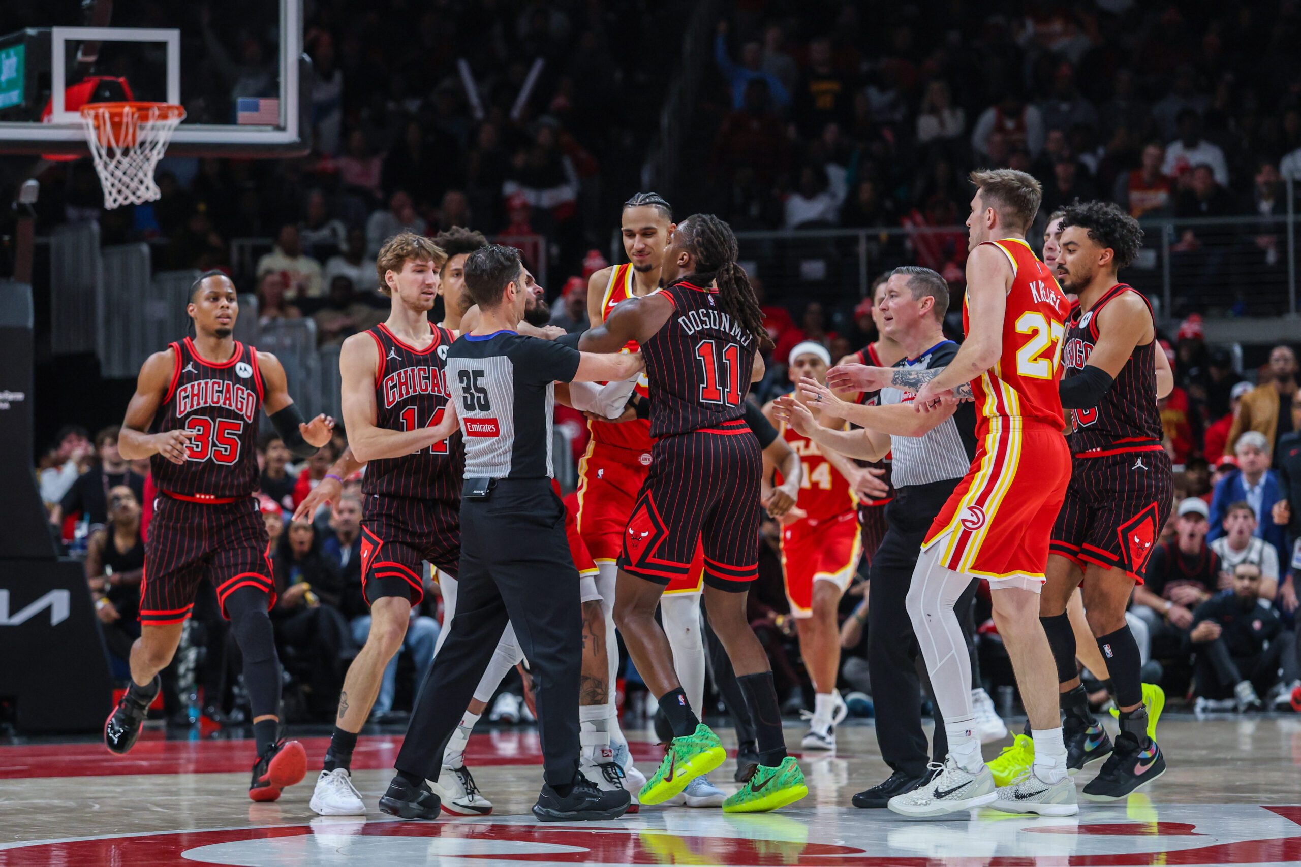 Dec 23, 2025; Atlanta, Georgia, USA; Atlanta Hawks guard Trae Young (11) starts a verbal altercation against Chicago Bulls guard Ayo Dosunmu (11) then referee Jason Goldenberg (35), guard Vit Krejci (27), forward Zaccharie Risacher (10), forward Matas Buzelis (14), guard Josh Giddey (3), and guard Tre Jones (30) step in during the fourth quarter at State Farm Arena. Mandatory Credit: Jordan Godfree-Imagn Images
