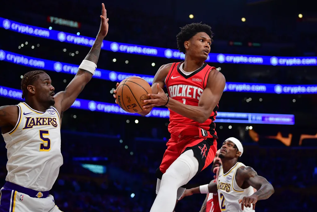 Dec 25, 2025; Los Angeles, California, USA; Houston Rockets guard Amen Thompson (1) passes the ball against the defense of Los Angeles Lakers center Deandre Ayton (5) during the second half at Crypto.com Arena. Mandatory Credit: Gary A. Vasquez-Imagn Images
