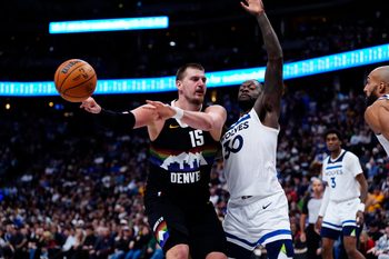 Dec 25, 2025; Denver, Colorado, USA; Denver Nuggets center Nikola Jokic (15) passes the ball away from Minnesota Timberwolves forward Julius Randle (30) in overtime at Ball Arena. Mandatory Credit: Ron Chenoy-Imagn Images