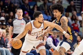 Dec 27, 2025; New Orleans, Louisiana, USA;  Phoenix Suns guard Devin Booker (1) dribbles against New Orleans Pelicans guard/forward Micah Peavy (14) during the second half at Smoothie King Center. Mandatory Credit: Stephen Lew-Imagn Images