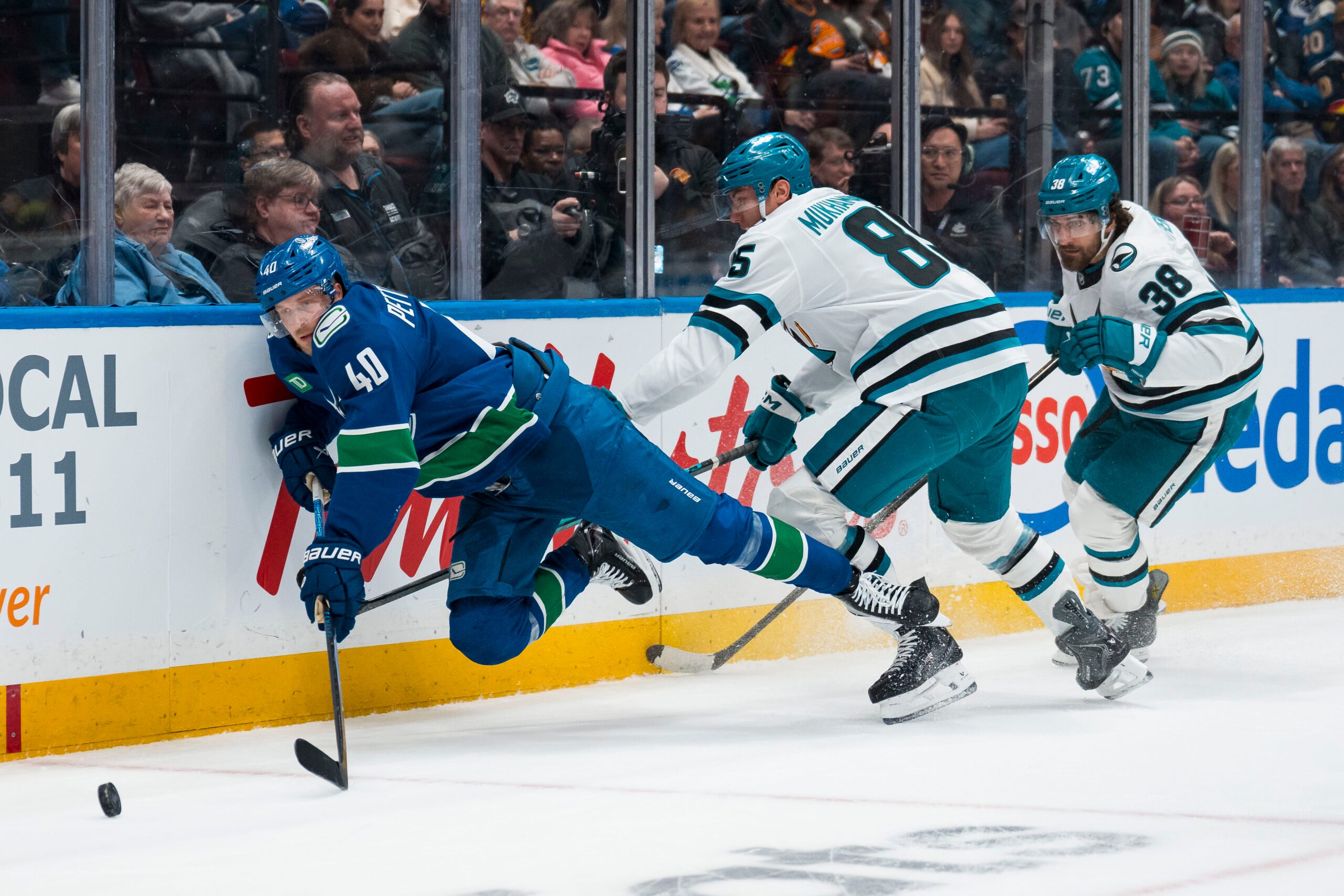 Dec 27, 2025; Vancouver, British Columbia, CAN; San Jose Sharks defenseman Mario Ferraro (38) watches as defenseman Shakir Mukhamadullin (85) checks Vancouver Canucks forward Elias Pettersson (40) in the second period at Rogers Arena. Mandatory Credit: Bob Frid-Imagn Images