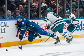 Dec 27, 2025; Vancouver, British Columbia, CAN; San Jose Sharks defenseman Mario Ferraro (38) watches as defenseman Shakir Mukhamadullin (85) checks Vancouver Canucks forward Elias Pettersson (40) in the second period at Rogers Arena. Mandatory Credit: Bob Frid-Imagn Images