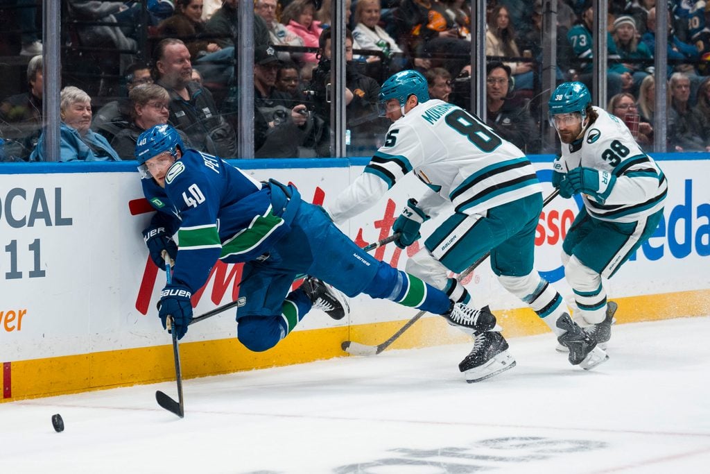 Dec 27, 2025; Vancouver, British Columbia, CAN; San Jose Sharks defenseman Mario Ferraro (38) watches as defenseman Shakir Mukhamadullin (85) checks Vancouver Canucks forward Elias Pettersson (40) in the second period at Rogers Arena. Mandatory Credit: Bob Frid-Imagn Images