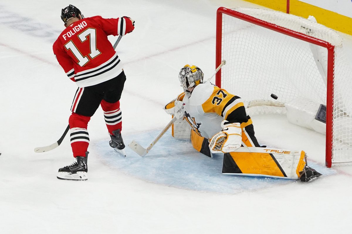 Dec 28, 2025; Chicago, Illinois, USA; Chicago Blackhawks left wing Nick Foligno (17) scores a goal with a backward shot through his legs on Pittsburgh Penguins goaltender Arturs Silovs (37) during the second period at United Center. Mandatory Credit: David Banks-Imagn Images