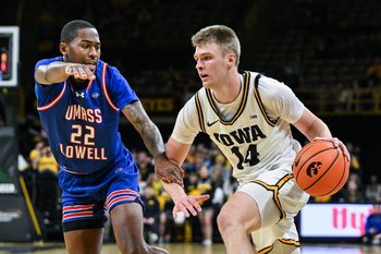 Dec 29, 2025; Iowa City, Iowa, USA; Iowa Hawkeyes guard Bennett Stirtz (14) controls the ball as UMass Lowell River Hawks guard Khalil Farmer (22) defends during the second half at Carver-Hawkeye Arena. Mandatory Credit: Jeffrey Becker-Imagn Images