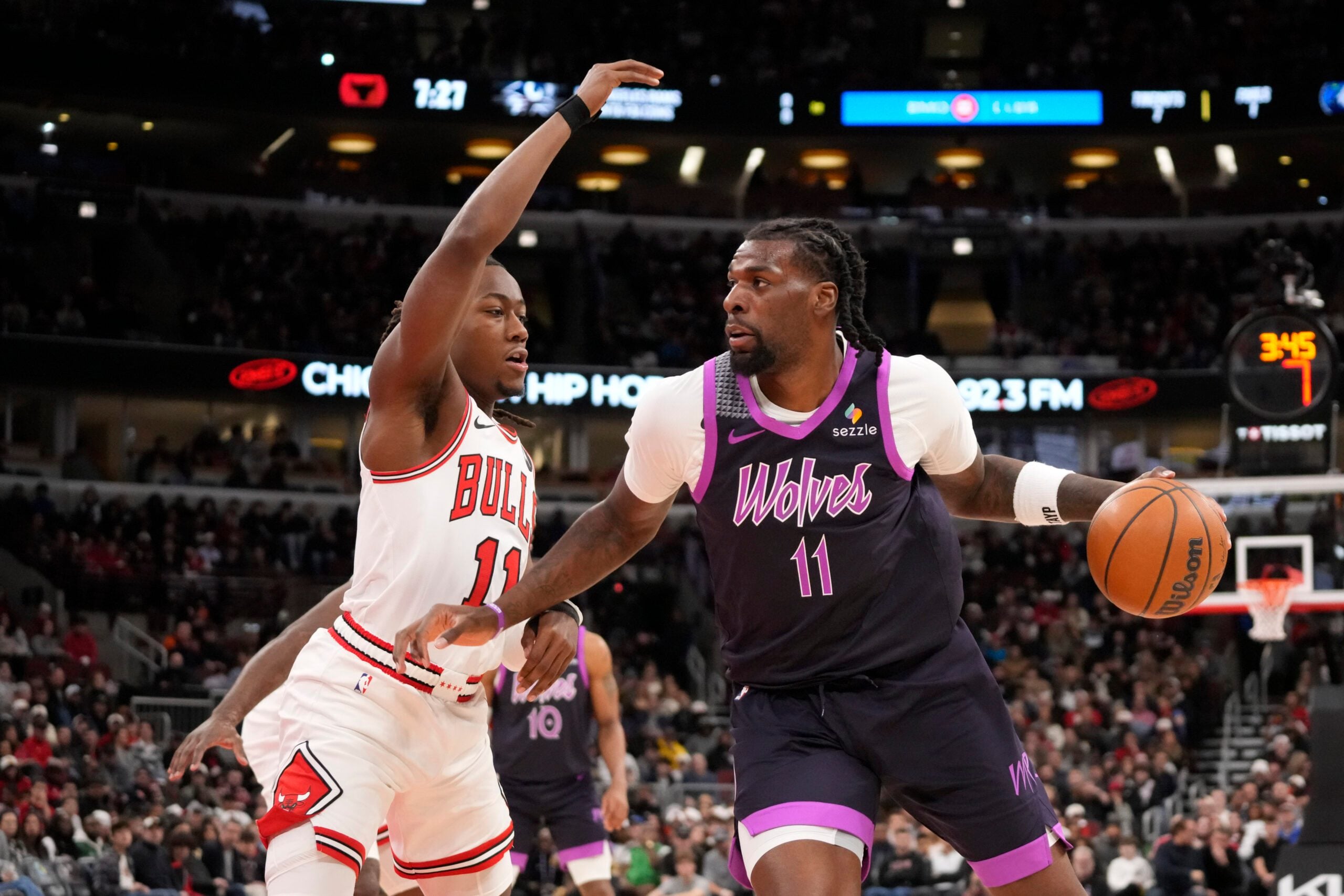 Dec 29, 2025; Chicago, Illinois, USA; Chicago Bulls guard Ayo Dosunmu (11) defends Minnesota Timberwolves center Naz Reid (11) during the first half at United Center. Mandatory Credit: David Banks-Imagn Images