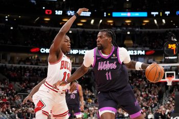 Dec 29, 2025; Chicago, Illinois, USA; Chicago Bulls guard Ayo Dosunmu (11) defends Minnesota Timberwolves center Naz Reid (11) during the first half at United Center. Mandatory Credit: David Banks-Imagn Images