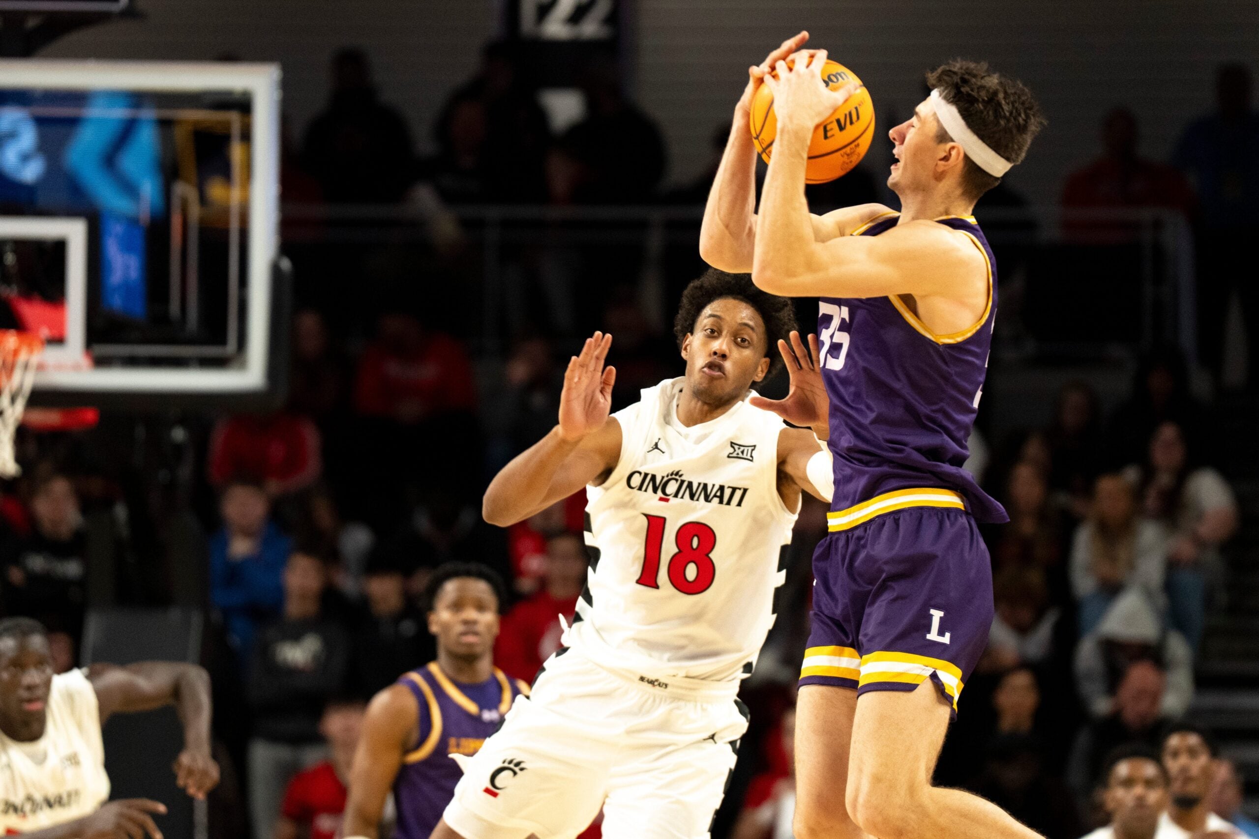 Lipscomb Bisons forward Grant Asman (35) catches a pass as Cincinnati Bearcats forward Baba Miller (18) guards him in the second half of the NCAA basketball game at Fifth Third Arena in Cincinnati on Dec. 29, 2025.