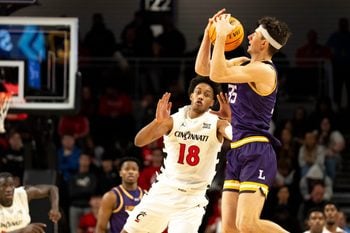 Lipscomb Bisons forward Grant Asman (35) catches a pass as Cincinnati Bearcats forward Baba Miller (18) guards him in the second half of the NCAA basketball game at Fifth Third Arena in Cincinnati on Dec. 29, 2025.