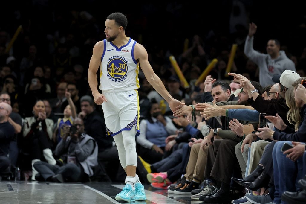 Dec 29, 2025; Brooklyn, New York, USA; Golden State Warriors guard Stephen Curry (30) high fives a fan during the fourth quarter against the Brooklyn Nets at Barclays Center. Mandatory Credit: Brad Penner-Imagn Images