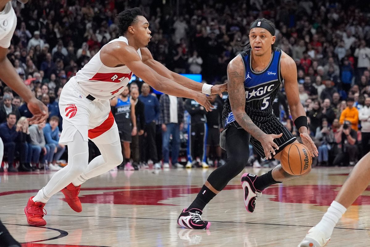 Dec 29, 2025; Toronto, Ontario, CAN; Orlando Magic forward Paolo Banchero (5) dribbles past Toronto Raptors guard Scottie Barnes (4) during the second half at Scotiabank Arena. Mandatory Credit: John E. Sokolowski-Imagn Images
