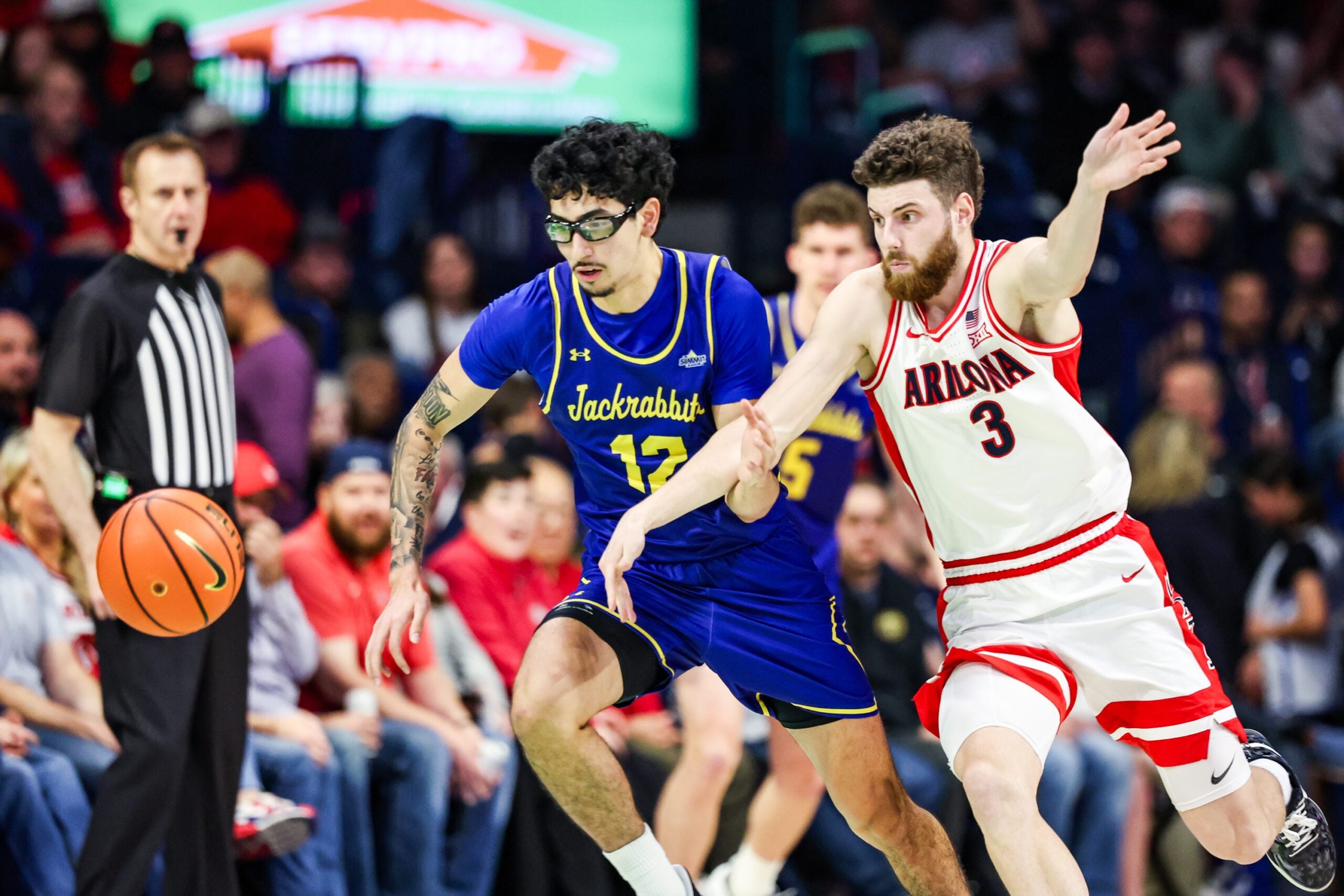 Dec 29, 2025; Tucson, Arizona, USA; South Dakota State Jackrabbits guard Bubz Alvarez (12) and Arizona Wildcats guard Anthony Dell’Orso (3) both run for the ball during the second half of the game at McKale Memorial Center. Mandatory Credit: Aryanna Frank-Imagn Images