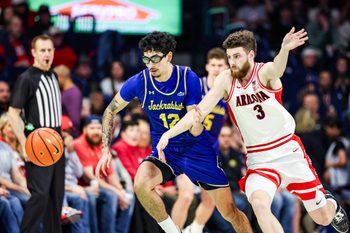 Dec 29, 2025; Tucson, Arizona, USA; South Dakota State Jackrabbits guard Bubz Alvarez (12) and Arizona Wildcats guard Anthony Dell’Orso (3) both run for the ball during the second half of the game at McKale Memorial Center. Mandatory Credit: Aryanna Frank-Imagn Images