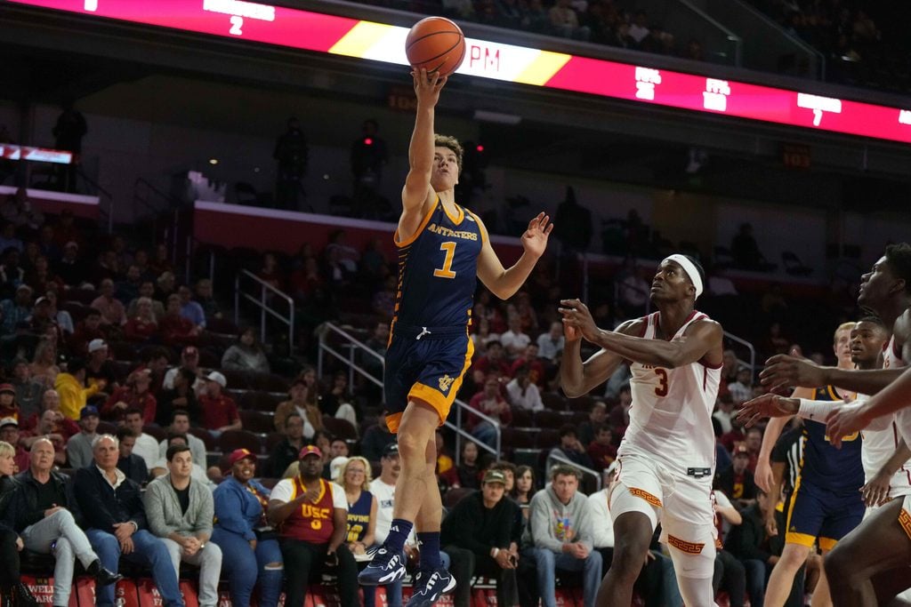 Nov 14, 2023; Los Angeles, California, USA; UC Irvine Anteaters guard Derin Saran (1) shoots the ball against Southern California Trojans forward Vincent Iwuchukwu (3) in the first half at Galen Center. Mandatory Credit: Kirby Lee-Imagn Images
