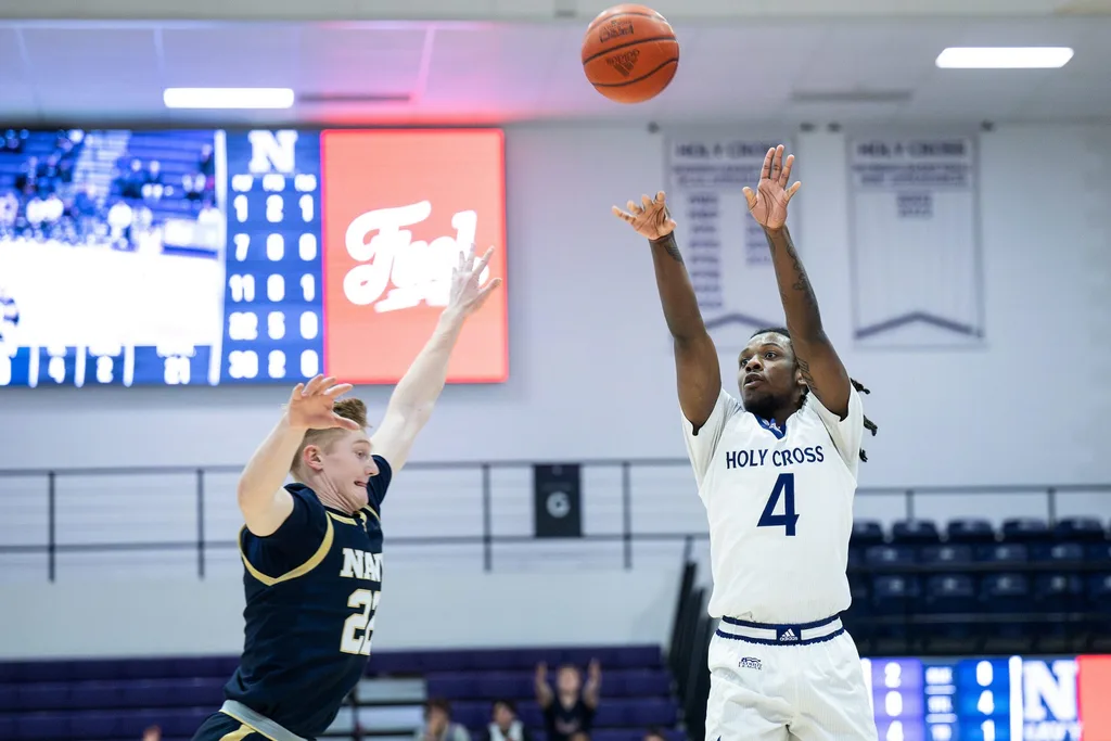 Holy Cross' Kahlil Singleton shoots as Navy's Mac MacDonald defends during Wednesday night's game at the Hart Center.