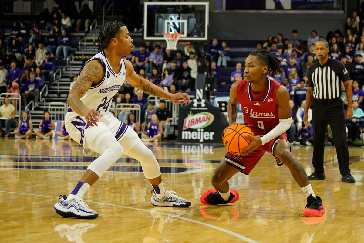 Nov 12, 2024; Evanston, Illinois, USA; Northwestern Wildcats guard K.J. Windham (24) defends Illinois-Chicago Flames guard Ahmad Henderson II (0) during the first half at Welsh-Ryan Arena. Mandatory Credit: David Banks-Imagn Images