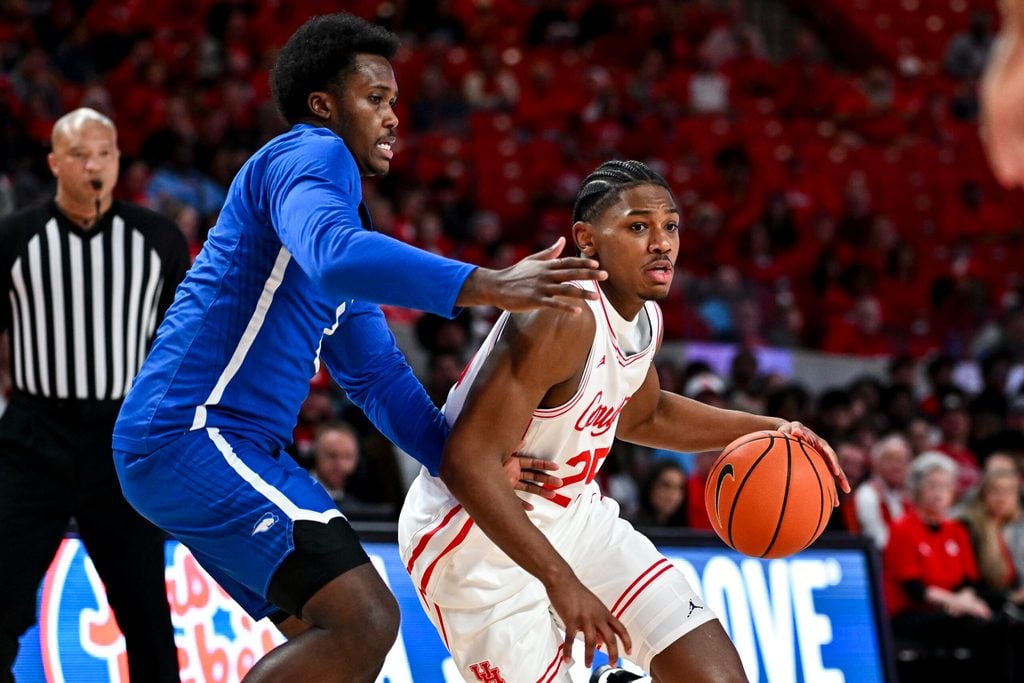 Nov 22, 2024; Houston, Texas, USA; Houston Cougars guard Mercy Miller (25) drives against Hofstra Pride guard Jaquan Sanders (2) during the first half at Fertitta Center. Mandatory Credit: Maria Lysaker-Imagn Images
