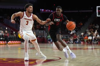Dec 18, 2024; Los Angeles, California, USA; Cal State Northridge Matadors guard Scotty Washington (12) dribbles the ball against Southern California Trojans forward Matt Knowling (3) in the first half at Galen Center. Mandatory Credit: Kirby Lee-Imagn Images