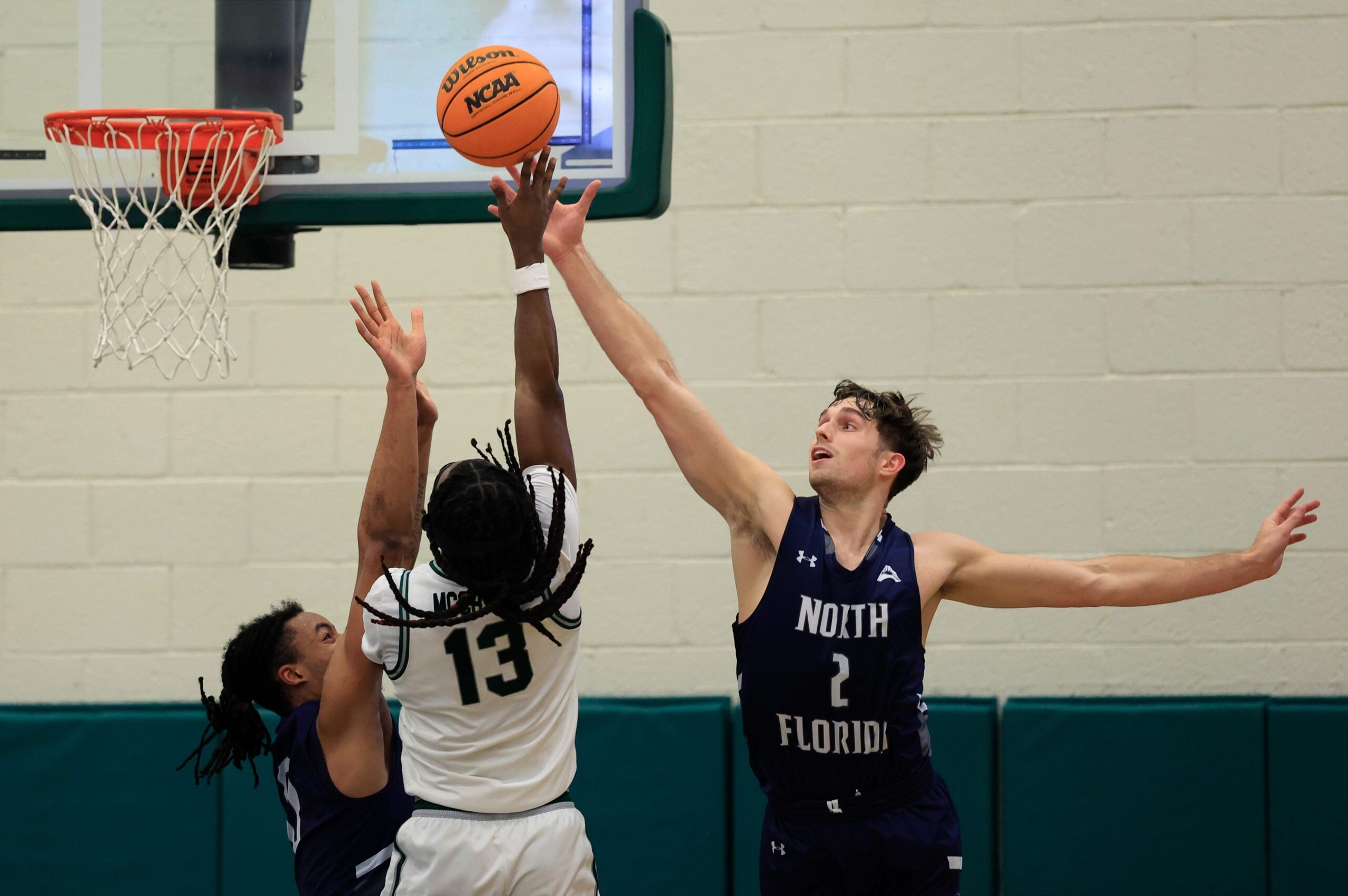 North Florida Ospreys guard Jasai Miles (0), left, and guard Nate Lliteras (2) defend against Jacksonville Dolphins guard Robert McCray V (13) during the second half of an NCAA men’s basketball matchup Saturday, Feb. 1, 2025 at Jacksonville University in Jacksonville, Fla. UNF held off a late rally from JU defeating them 81-78. [Corey Perrine/Florida Times-Union]