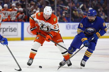 Feb 25, 2025; Buffalo, New York, USA;  Anaheim Ducks center Mason McTavish (23) and Buffalo Sabres right wing Alex Tuch (89) go after a loose puck during the first period at KeyBank Center. Mandatory Credit: Timothy T. Ludwig-Imagn Images