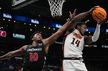 Cowboys Jamyron Keller (14) recovers the ball before Bearcats Josh Reed (10) during Game 1 of the 2025 Phillips 66 Big 12 Basketball Championship against the Oklahoma State Cowboys at the T-Mobile Center in Kansas City, Missouri on Tuesday March 11, 2025. Bearcats won the game with a final score of 87-68.