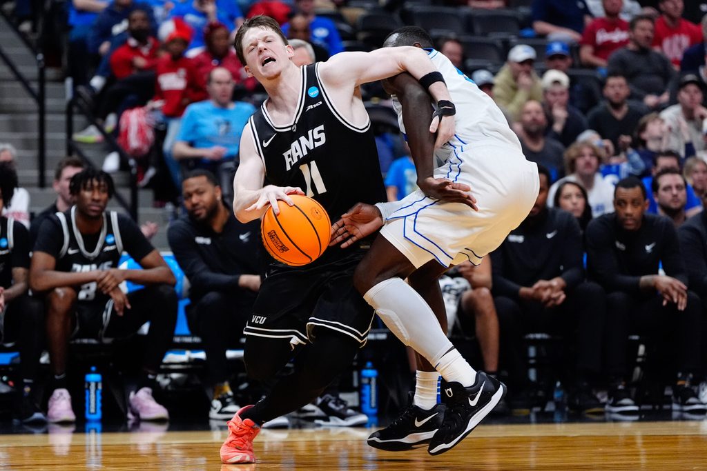 Mar 20, 2025; Denver, CO, USA; Brigham Young Cougars center Keba Keita (13) fouls VCU Rams guard Max Shulga (11) during the second half in the first round of the NCAA Tournament at Ball Arena. Mandatory Credit: Ron Chenoy-Imagn Images
