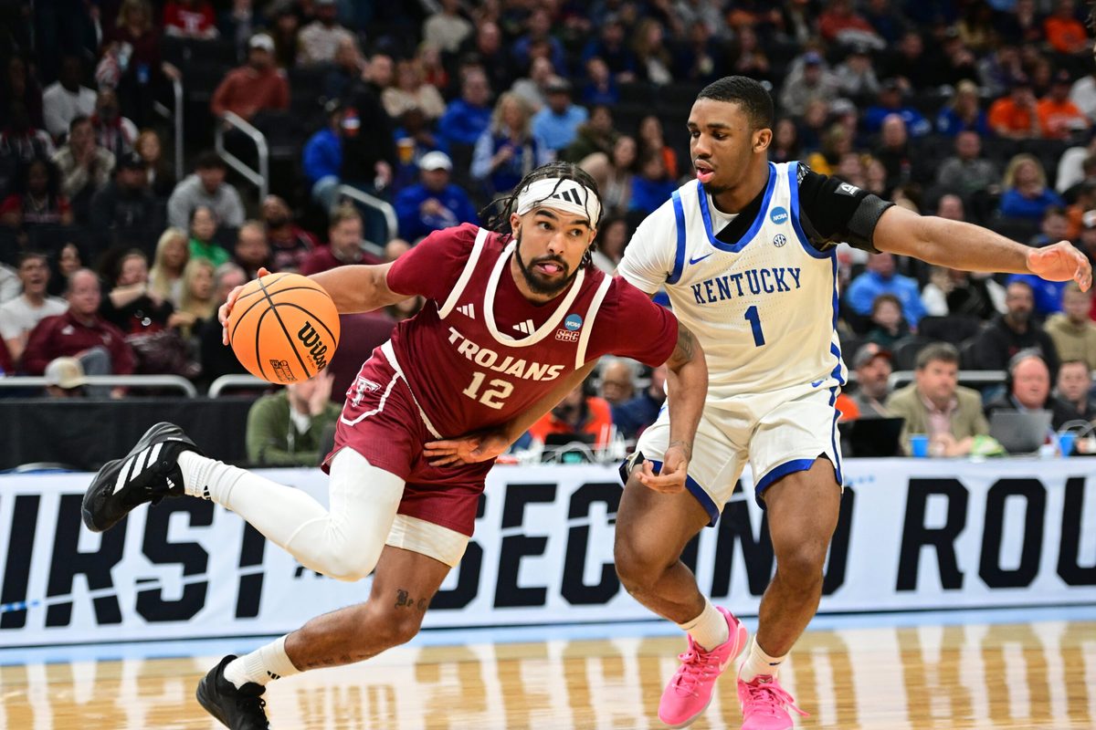 Mar 21, 2025; Milwaukee, WI, USA; Troy Trojans guard Tayton Conerway (12) drives to the hoop past Kentucky Wildcats guard Lamont Butler (1) during the second half at Fiserv Forum. Mandatory Credit: Benny Sieu-Imagn Images
