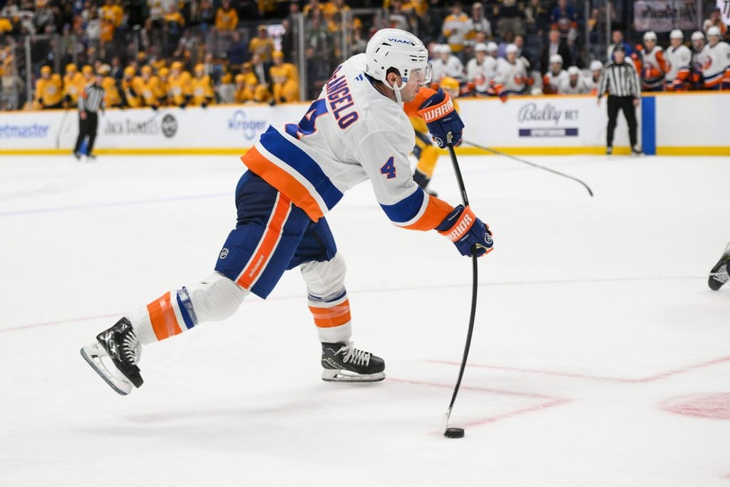 Apr 8, 2025; Nashville, Tennessee, USA; New York Islanders defenseman Tony DeAngelo (4) takes a shot on goal against the Nashville Predators during the over time period at Bridgestone Arena. Mandatory Credit: Steve Roberts-Imagn Images