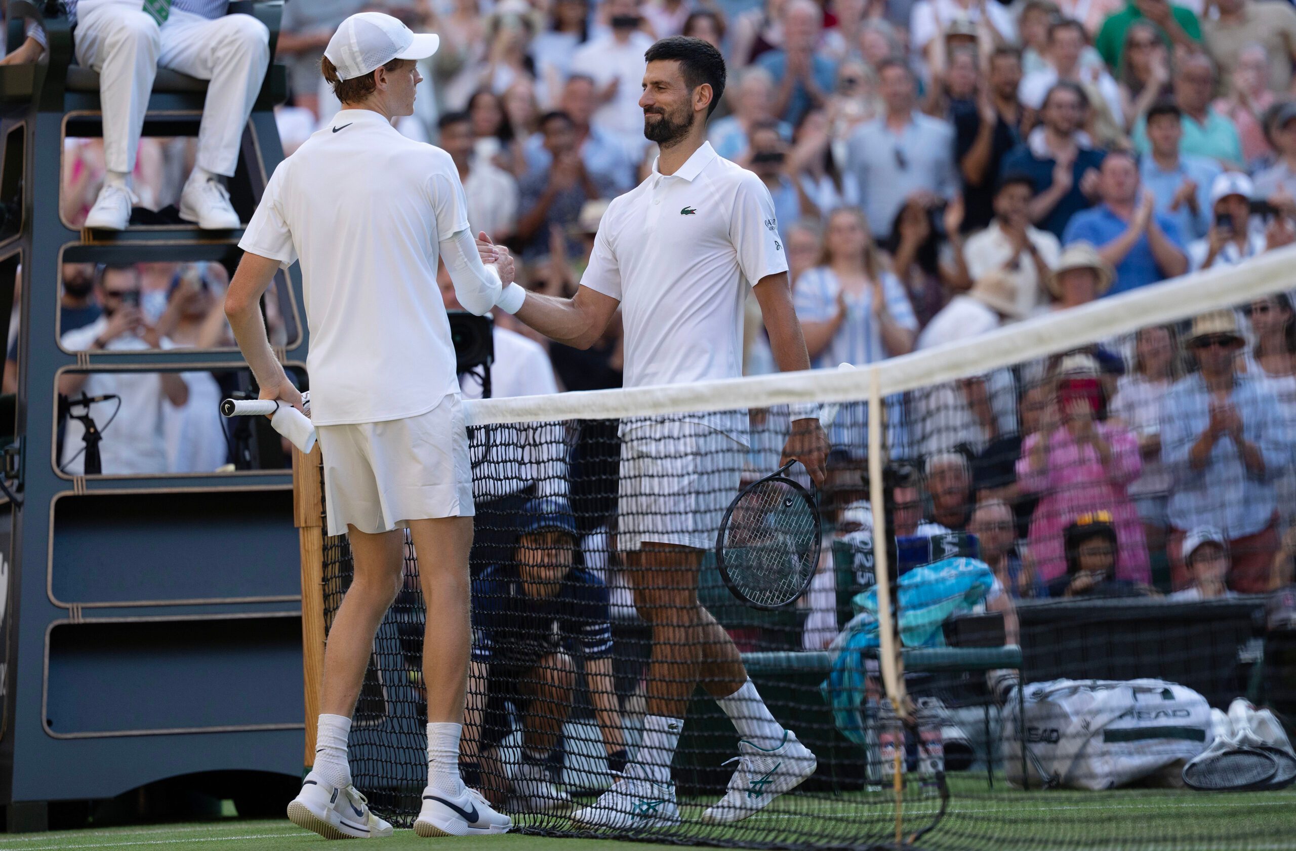 Jul 11, 2025; Wimbledon, United Kingdom; Jannik Sinner of Italy at the net with Novak Djokovic of Serbia after their match on day 12 at All England Lawn Tennis and Croquet Club. Mandatory Credit: Susan Mullane-Imagn Images