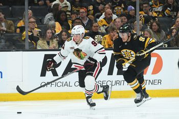 Oct 9, 2025; Boston, Massachusetts, USA; Chicago Blackhawks center Frank Nazar (91) controls the puck ahead of Boston Bruins defenseman Nikita Zadorov (91) during the second period at TD Garden. Mandatory Credit: Bob DeChiara-Imagn Images