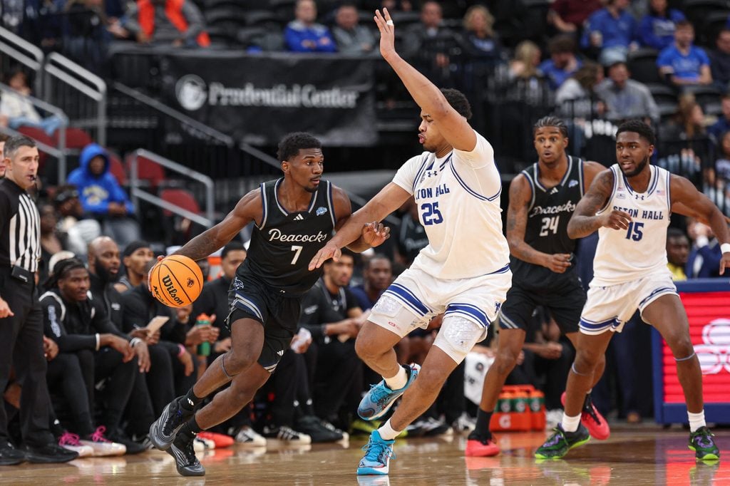 Nov 3, 2025; Newark, New Jersey, USA; Saint Peter's Peacocks guard Elijah Perkins (7) dribbles against Seton Hall Pirates center Najai Hines (25) during the second half at Prudential Center. Mandatory Credit: Vincent Carchietta-Imagn Images